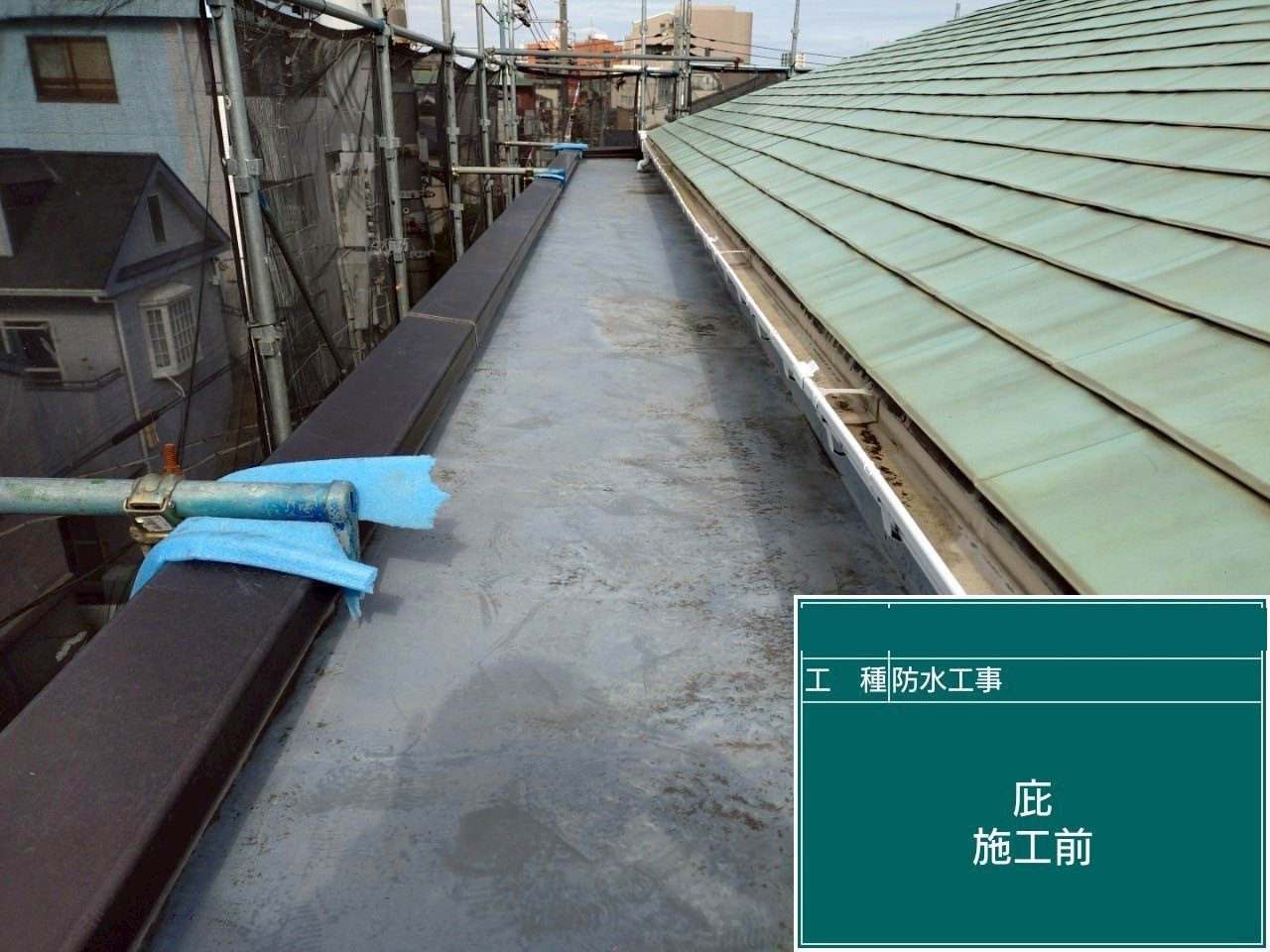 緑色の金属屋根の横に続く、工事前の細長い庇の床