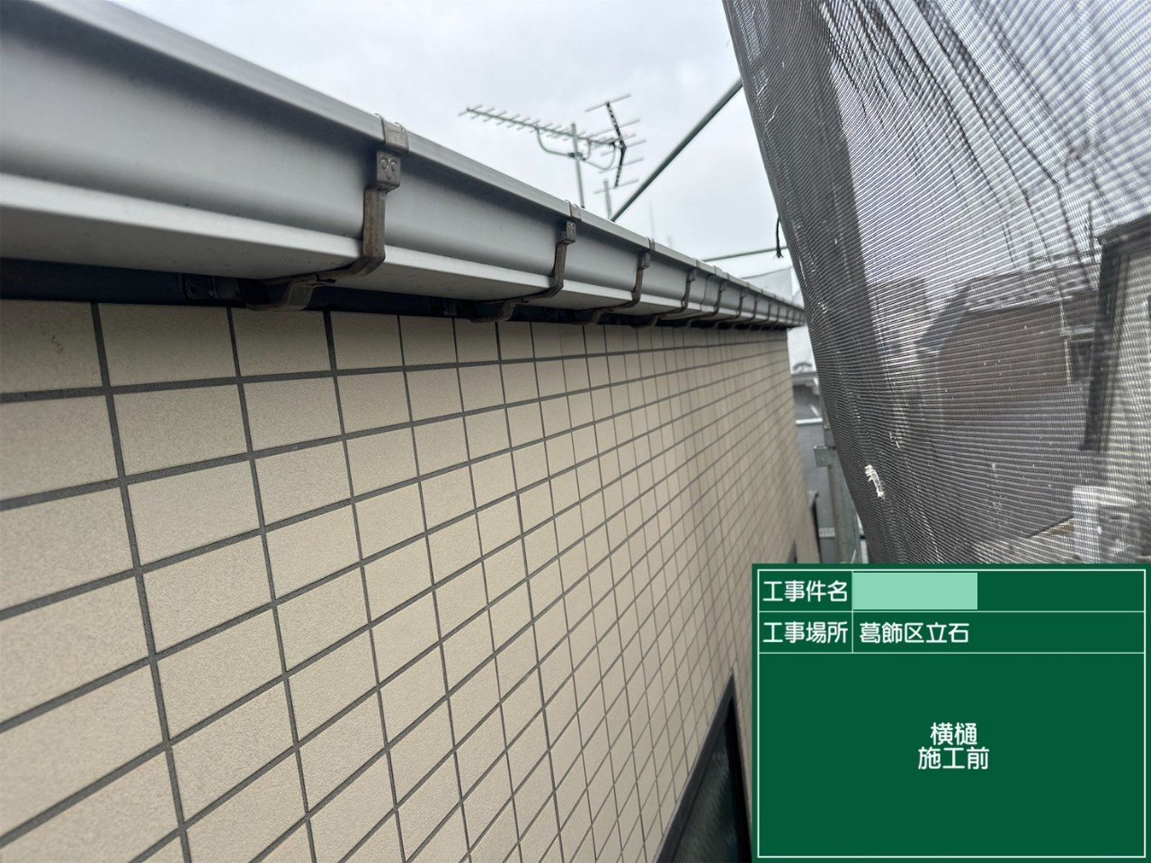 工事前のタイル外壁の上に付いた横樋