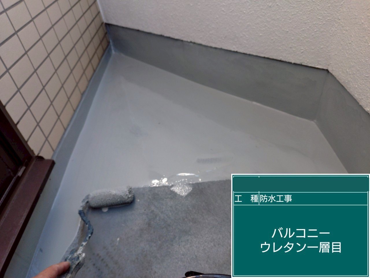 バルコニーの床にウレタン防水の1層目を塗っている様子
